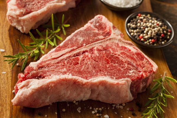 Thick,Raw,T-bone,Steak,With,Seasoning,And,Rosemary